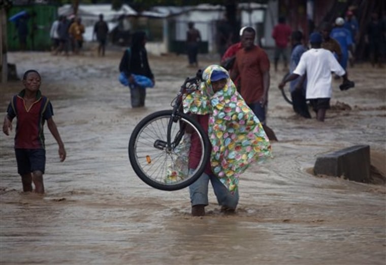 People wade through a flooded street during the passing of Hurricane Tomas in Leogane, Haiti, Friday, Nov. 5, 2010. (AP Photo/Ramon Espinosa)